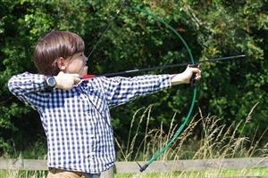 Boy with arrow concentrating on his bow aim